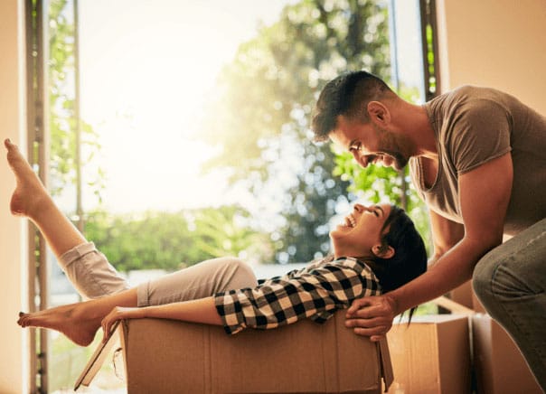 a man and a woman are interacting with a cardboard box